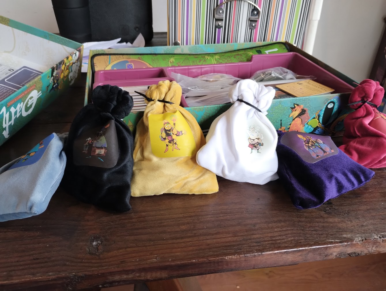 Las seis bolsas, llenas y cerradas, junto a la caja del juego