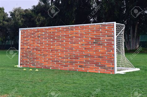 Foto de un arco de fútbol con un muro de ladrillos superpuesto